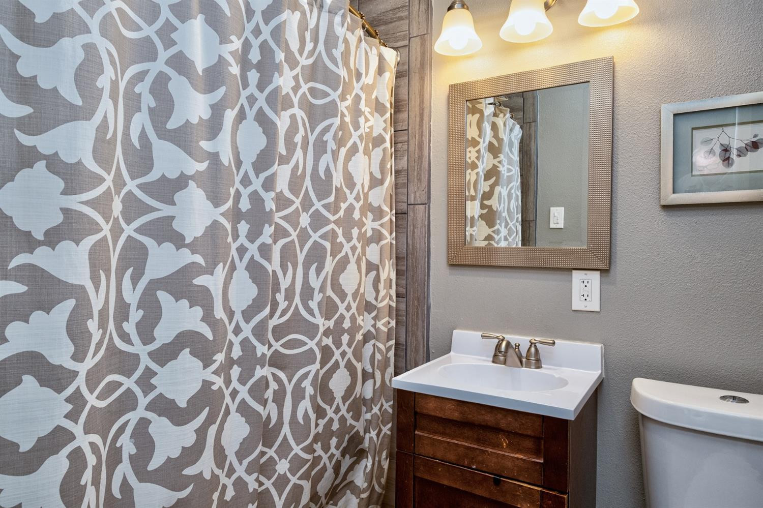 5209 16th Street Lubbock, TX 79416 - Photo 16 of 23 a bathroom with a sink a toilet and a mirror