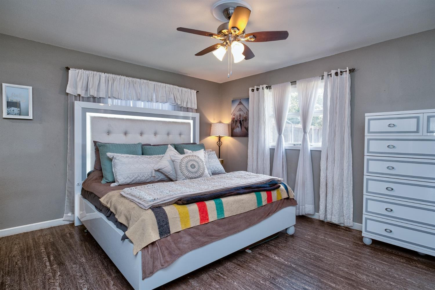 5209 16th Street Lubbock, TX 79416 - Photo 17 of 23 a bedroom with a bed and a chandelier