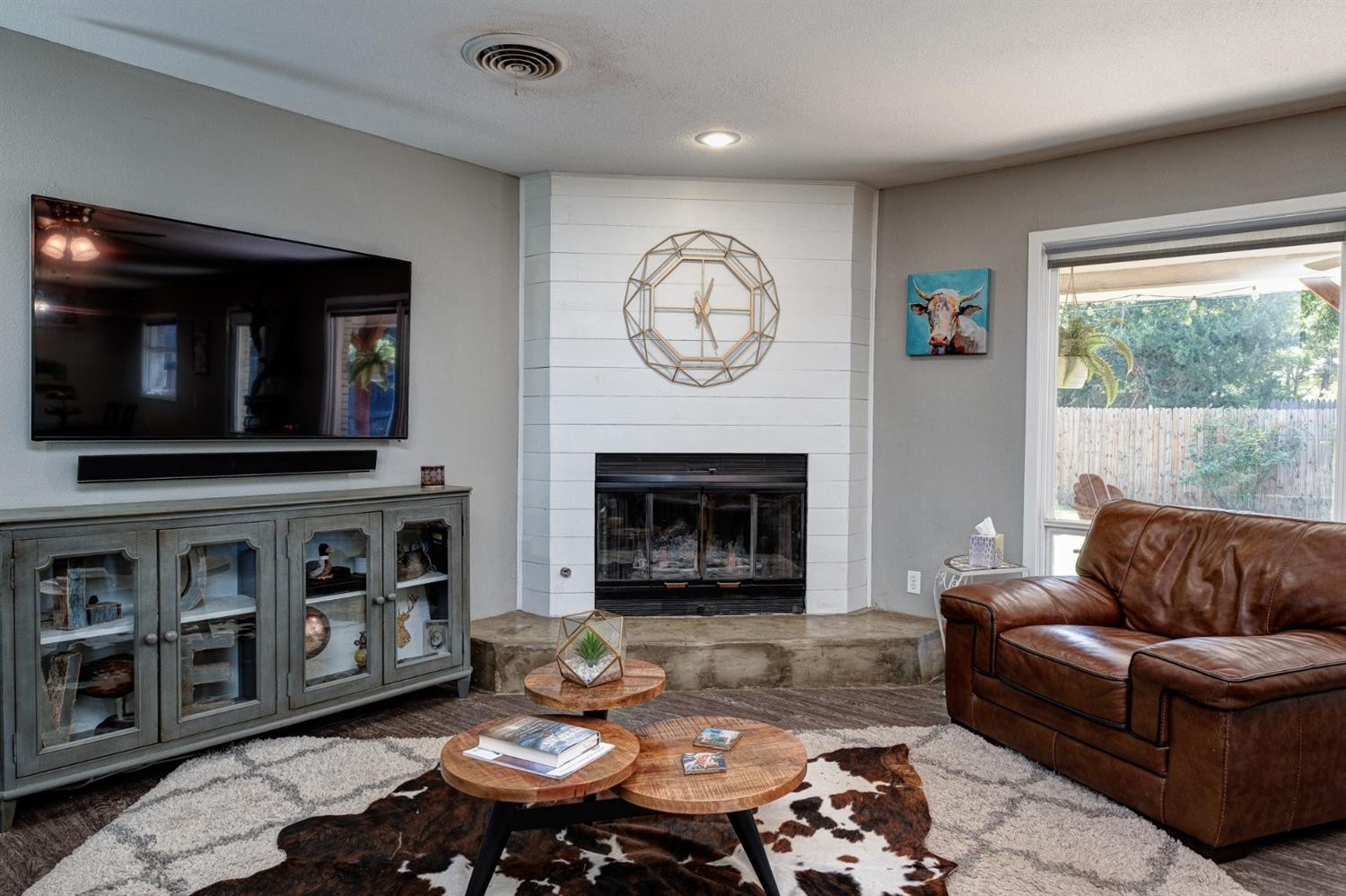 5209 16th Street Lubbock, TX 79416 - Photo 5 of 23 a living room with furniture a fireplace and a flat screen tv