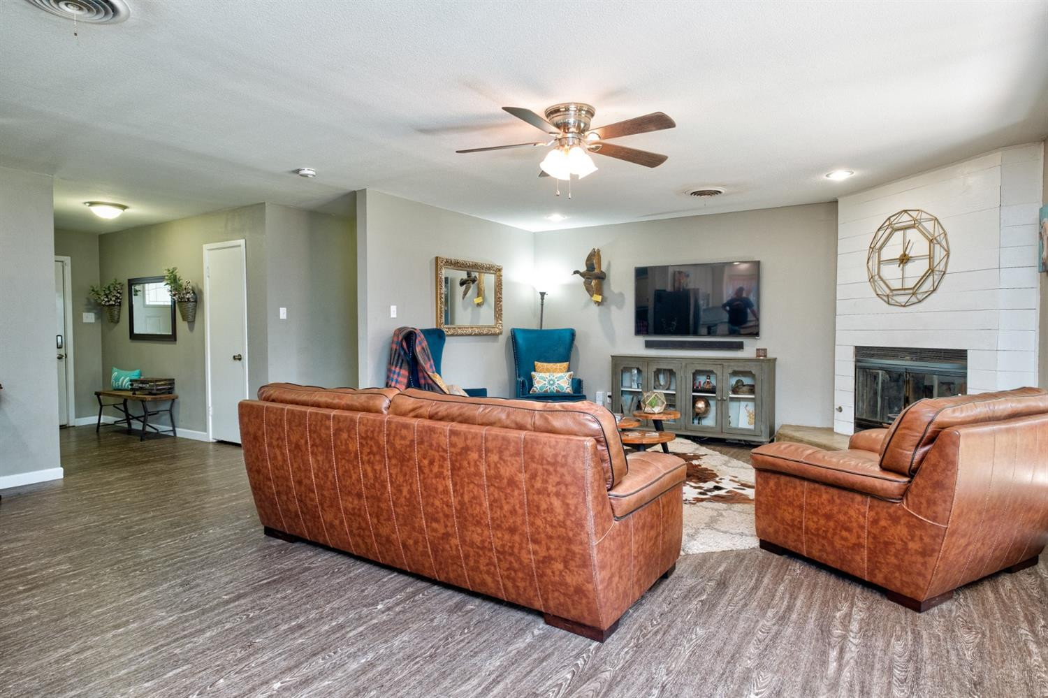 5209 16th Street Lubbock, TX 79416 - Photo 6 of 23 a living room with furniture a fireplace and a flat screen tv