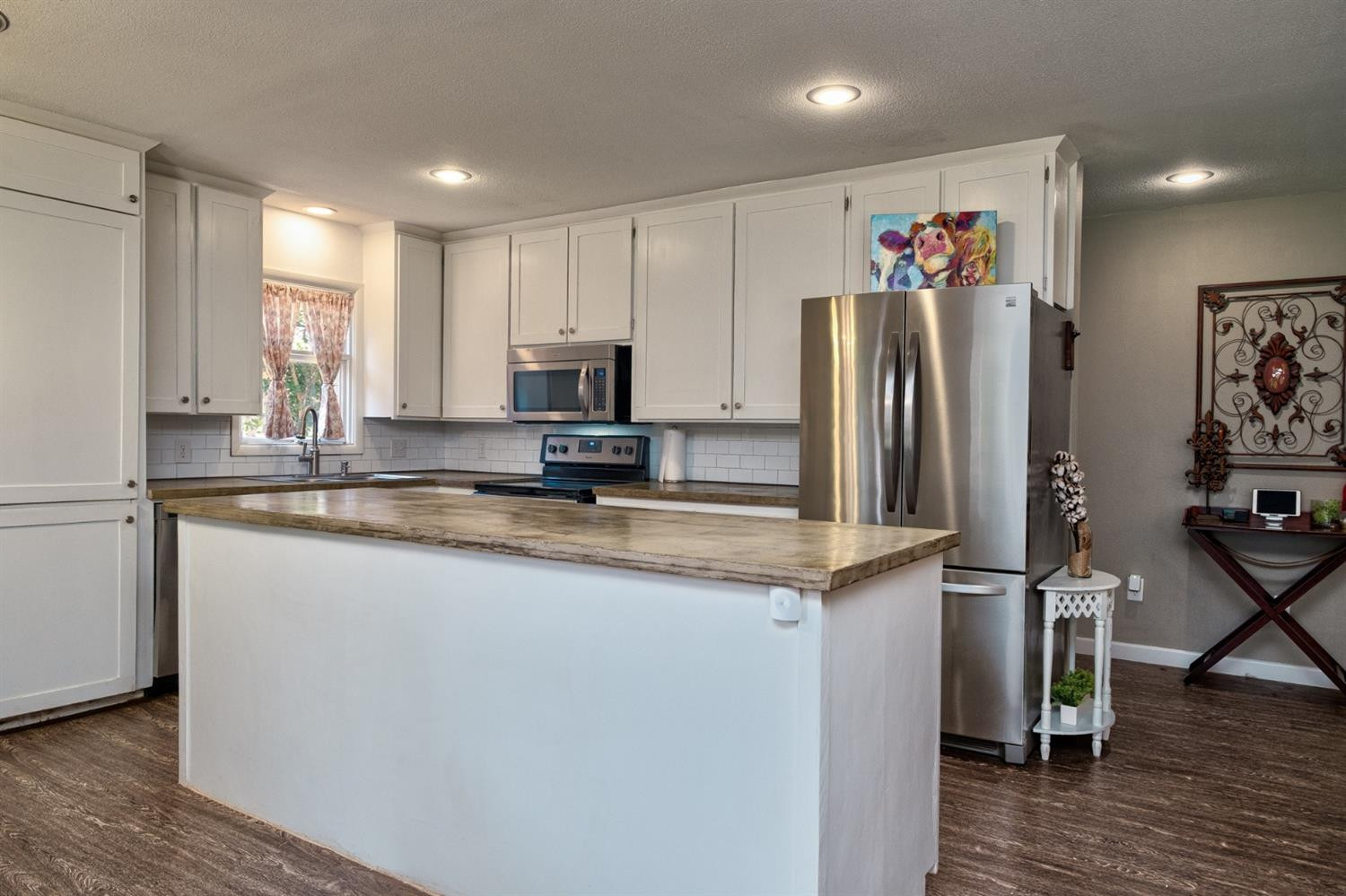 5209 16th Street Lubbock, TX 79416 - Photo 7 of 23 a kitchen with granite countertop a refrigerator and a sink