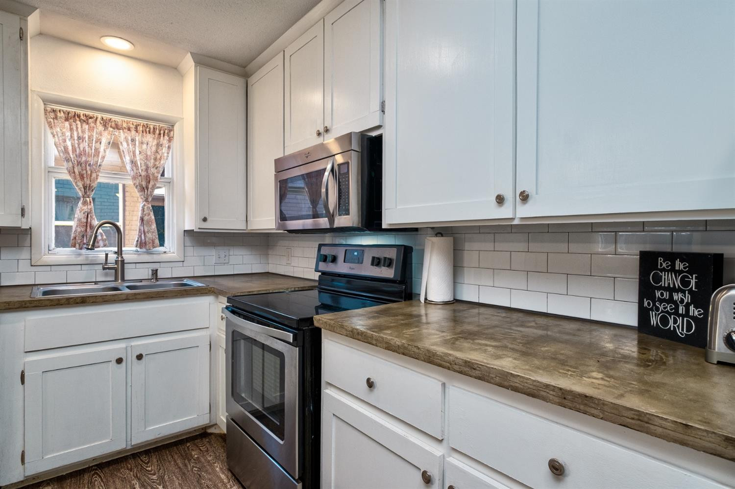 5209 16th Street Lubbock, TX 79416 - Photo 8 of 23 a kitchen with granite countertop white cabinets and a sink