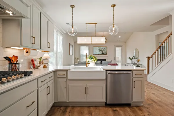 a kitchen with white cabinets and sink