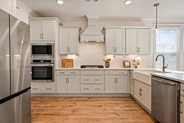 a kitchen with stainless steel appliances a stove sink and refrigerator