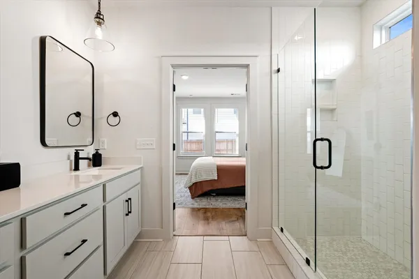 a en suite bathroom with a shower sink and mirror