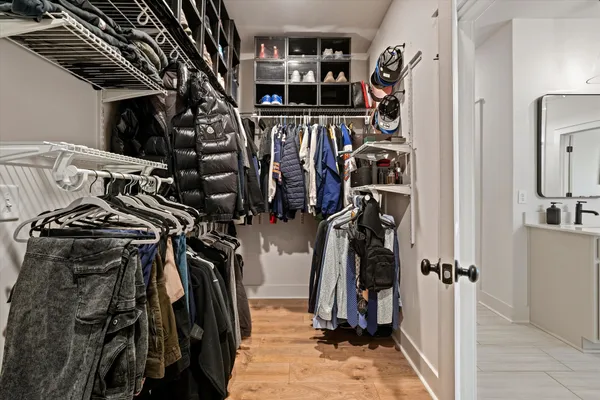 a view of walk in closet with clothes and shoes