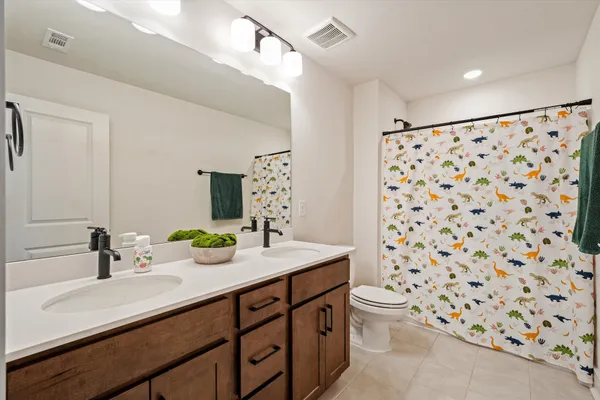 a bathroom with a sink a toilet and shower curtain