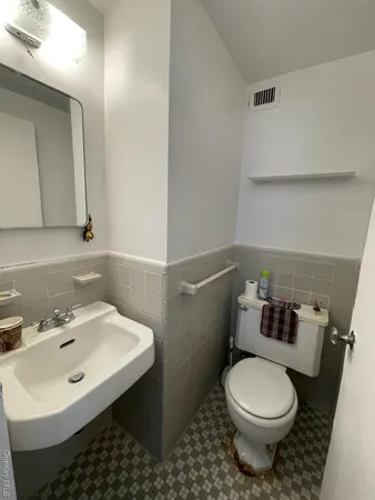 a bathroom with a sink toilet and mirror