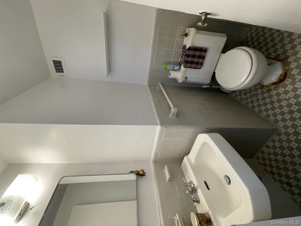 3 Fordham Hill Ovl, Unit 4G Bronx, NY 10468 - Photo 12 of 14 a bathroom with a sink toilet and mirror