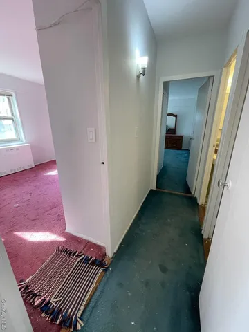 a view of a room with wooden floor and a bathroom