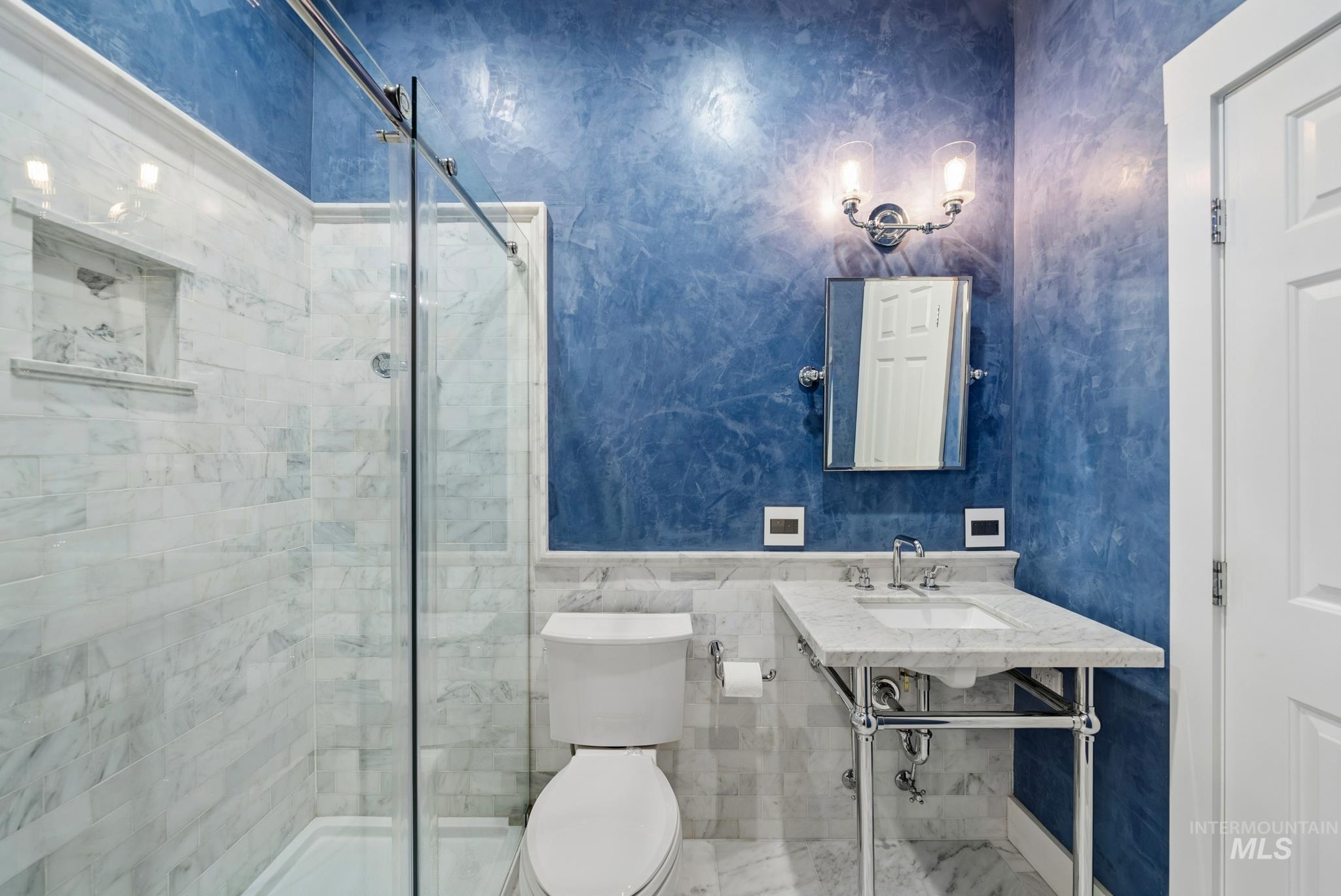 2050 Artesian Road Eagle, ID 83616 - Photo 44 of 49 Bathroom featuring a frameless glass shower enclosure, a recessed shower niche, a console vanity with a rectangular basin and chrome fixtures, and a wall-mounted vanity light