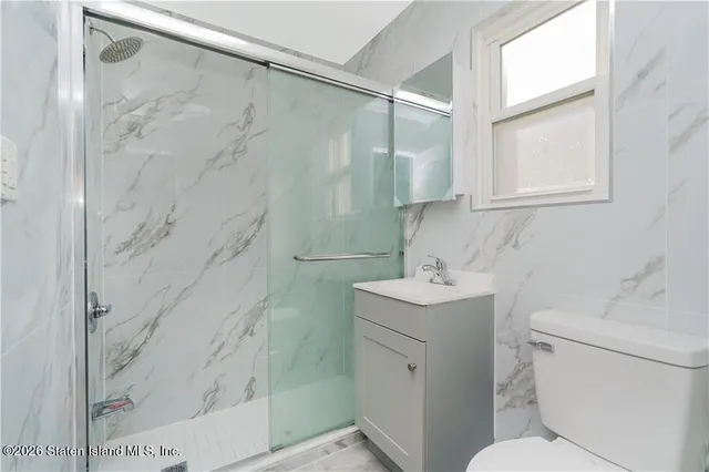 a bathroom with a sink toilet vanity and shower
