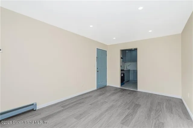 a view of an empty room with wooden floor