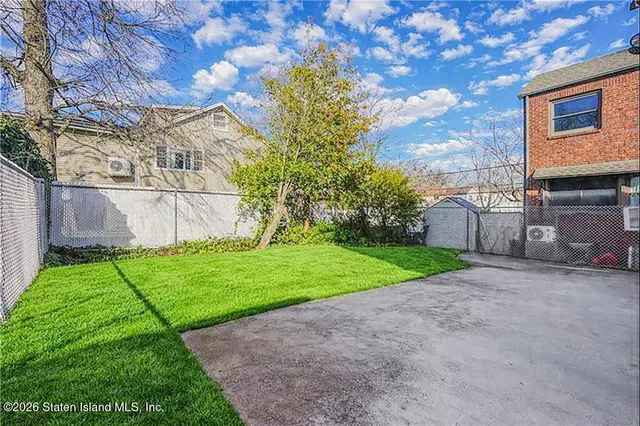 a view of a backyard with a garden and entertaining space