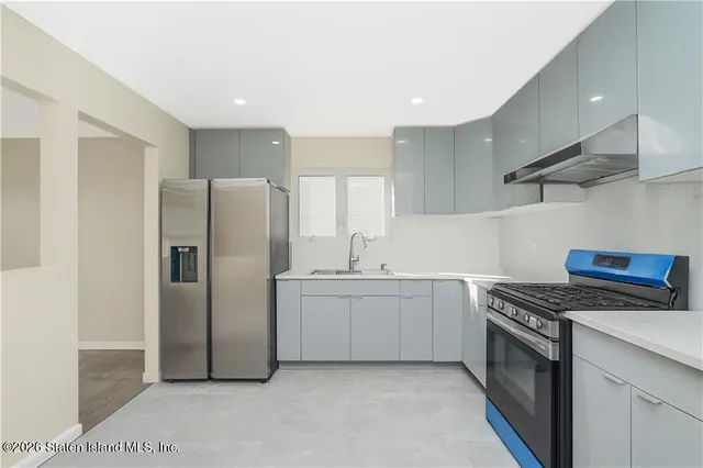 a kitchen with stainless steel appliances granite countertop a refrigerator a sink and a stove