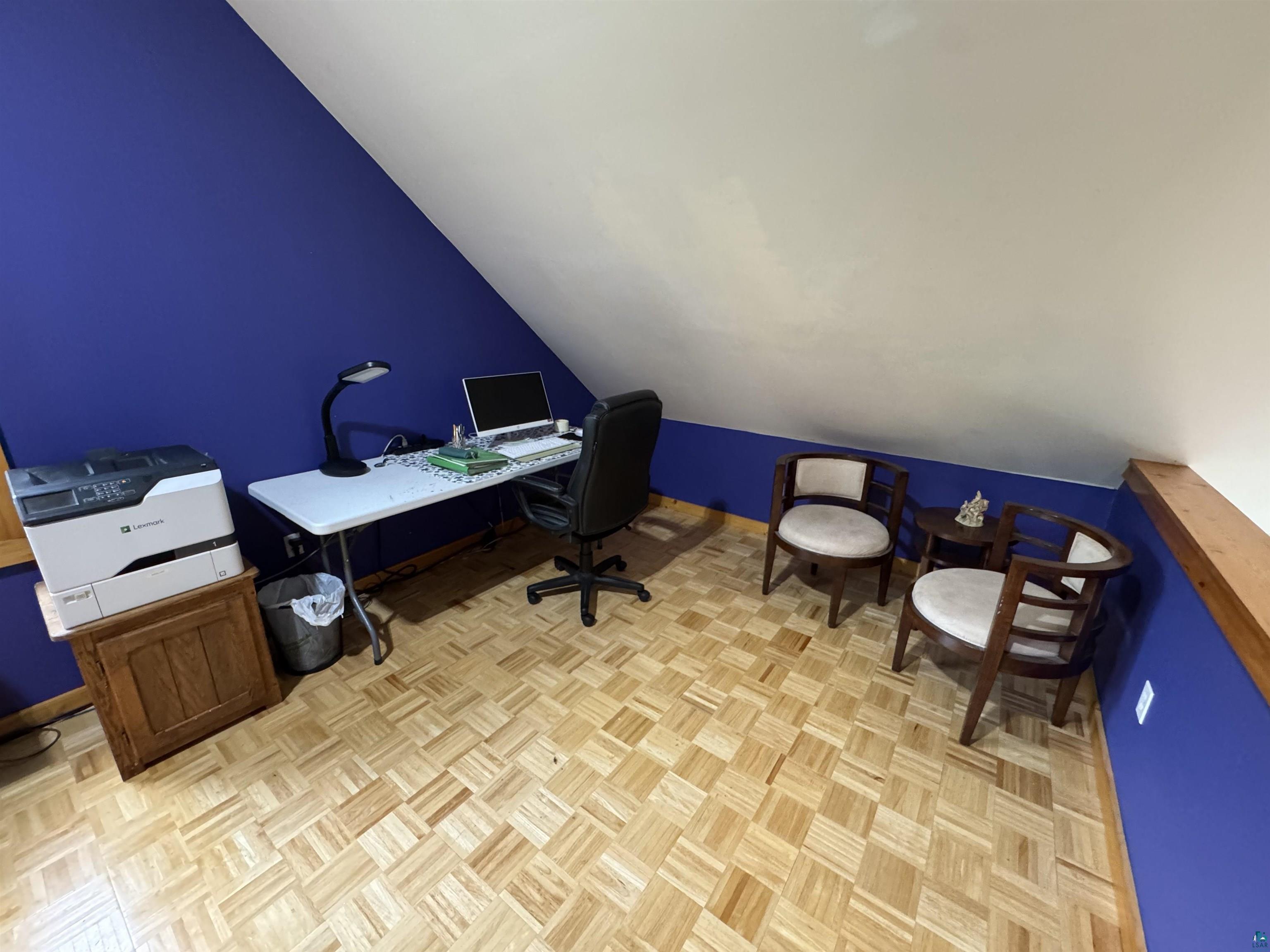 1745 Becks Road Maple, WI 54854 - Photo 25 of 46 Room featuring patterned wood-finish flooring, a vibrant accent wall, and a sloped ceiling