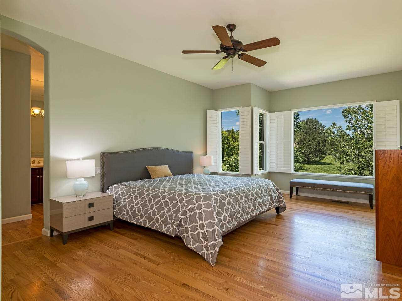 1755 Caughlin Creek Road Reno, NV 89519 - Photo 12 of 25 a bedroom with a bed a large window and wooden floor