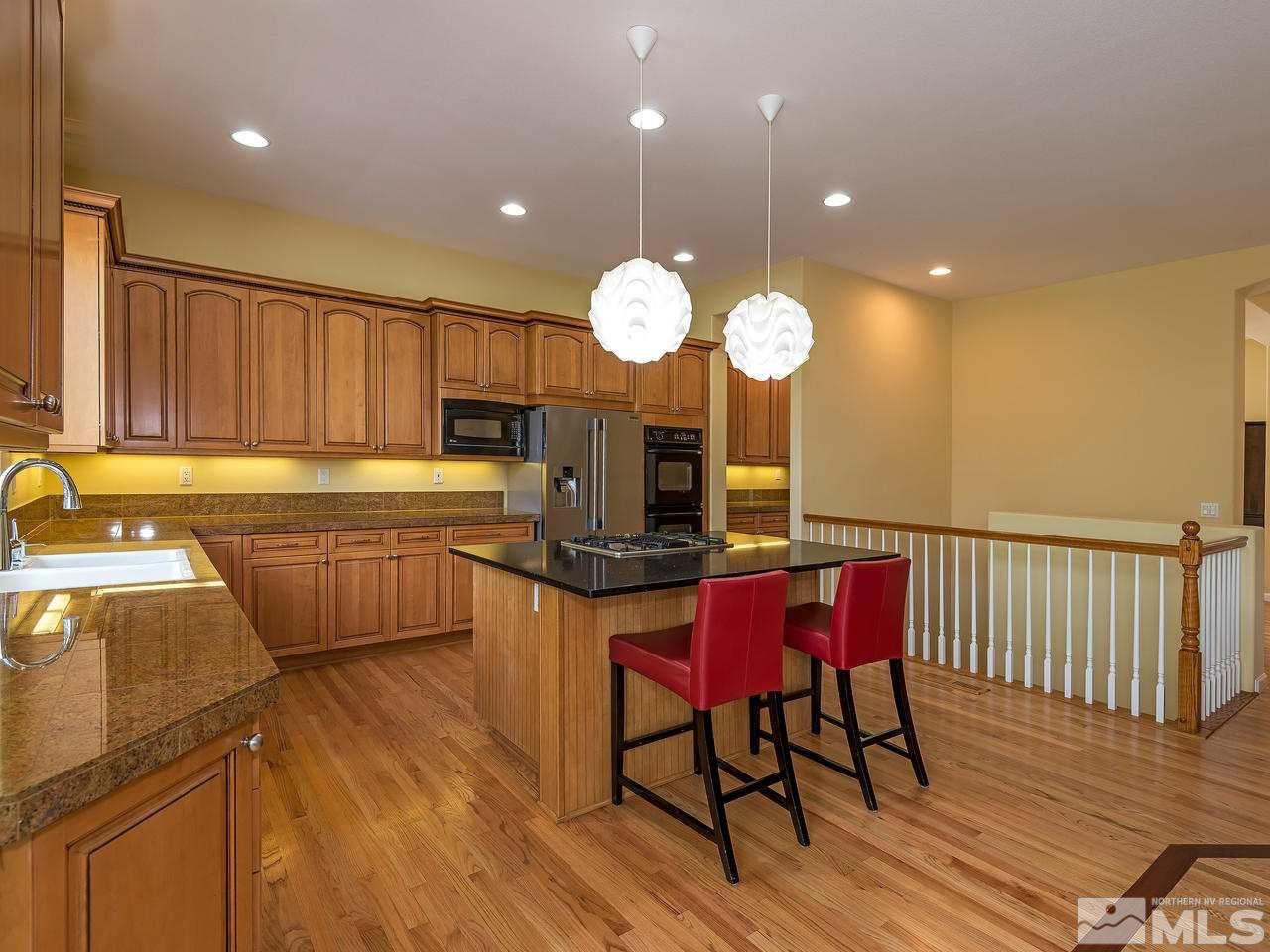 1755 Caughlin Creek Road Reno, NV 89519 - Photo 7 of 25 a kitchen with a table chairs stainless steel appliances and wooden floor