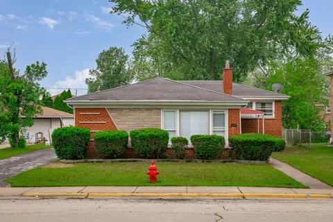 a front view of a house with a yard and potted plants