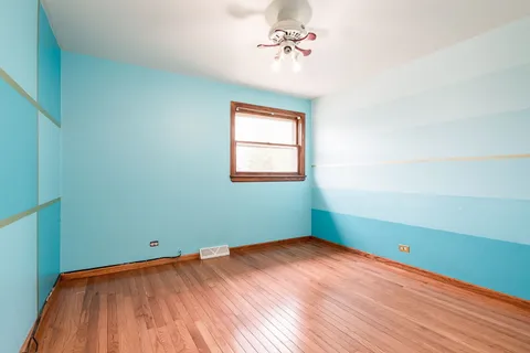 an empty room with a window and a ceiling fan