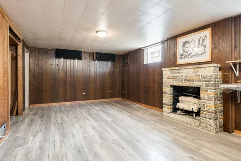a view of a livingroom with wooden floor and a fireplace