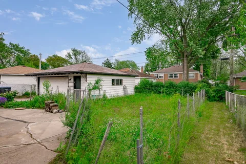 a view of a house with a big yard plants and large trees