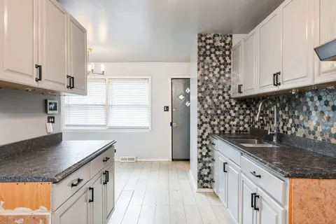 a kitchen with granite countertop a sink and a stove