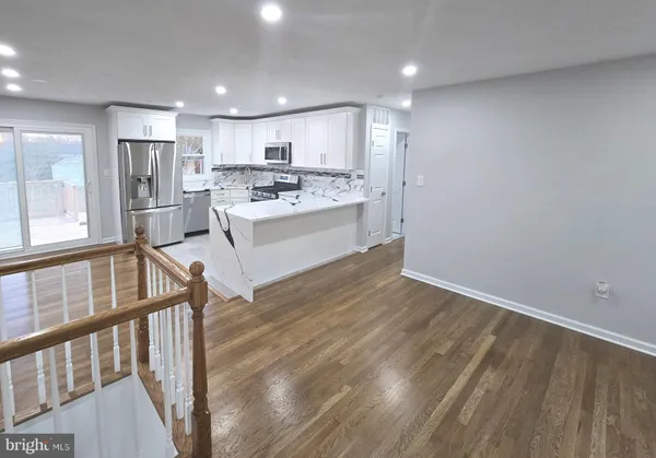 a view of a living room a dining room with wooden floor and a fireplace