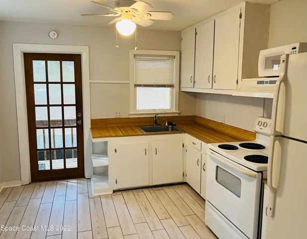 a kitchen with granite countertop white cabinets and white appliances