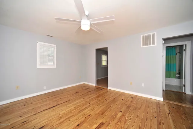 a view of an empty room with wooden floor