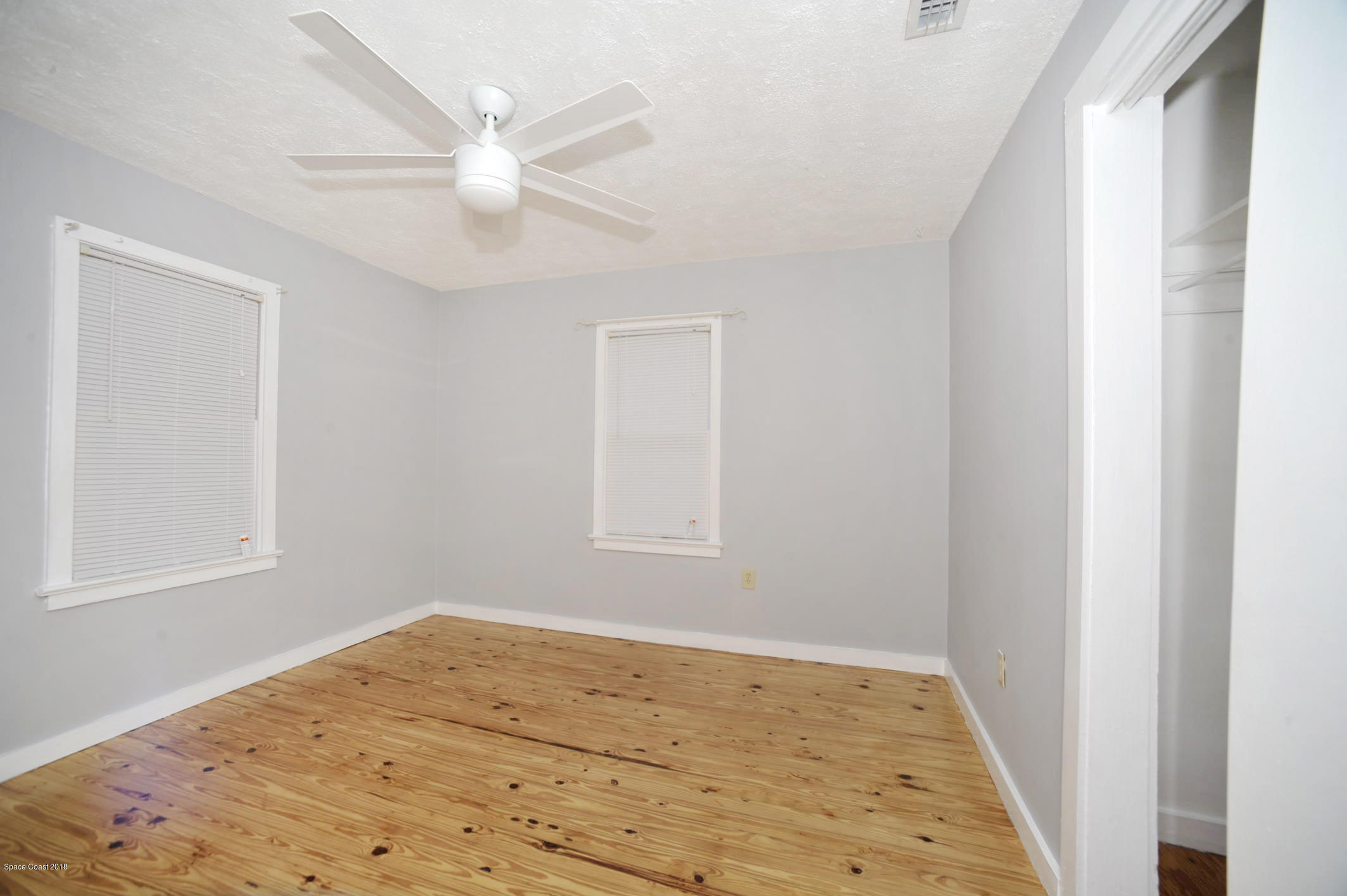 19 Highland Street Cocoa, FL 32922 - Photo 6 of 9 a view of an empty room with wooden floor and a ceiling fan
