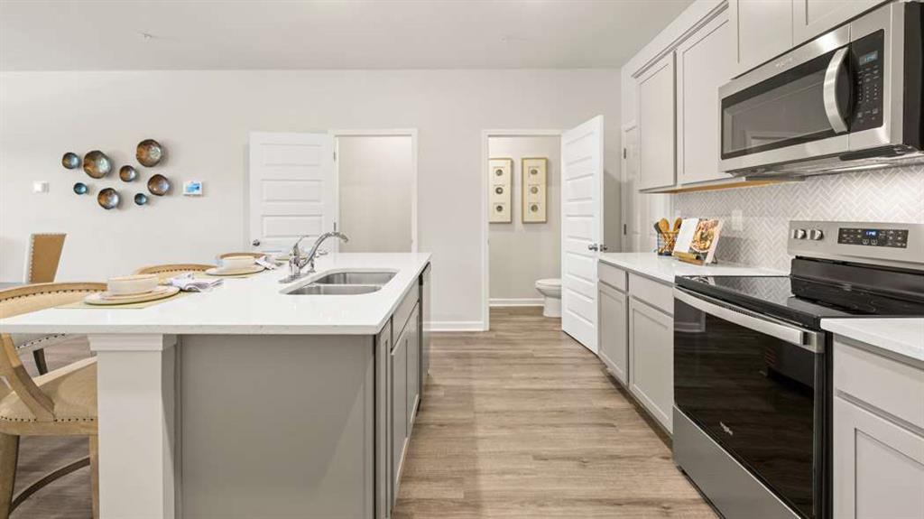 424 Reflection Drive Stockbridge, GA 30281 - Photo 15 of 66 a kitchen with stainless steel appliances granite countertop a sink and dishwasher a stove top oven with wooden floor
