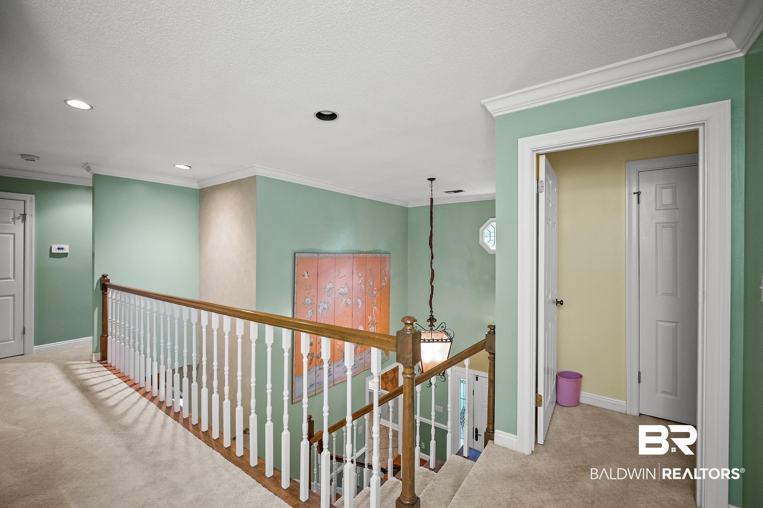329 Norwood Road Monroeville, AL 36460 - Photo 29 of 49 Upper-level hallway featuring plush carpeting, crown molding, recessed lighting, and a white baluster railing with a natural wood handrail