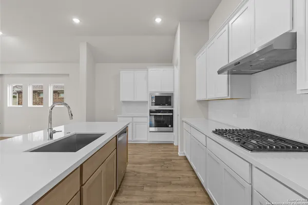a kitchen with stainless steel appliances a sink stove and cabinets