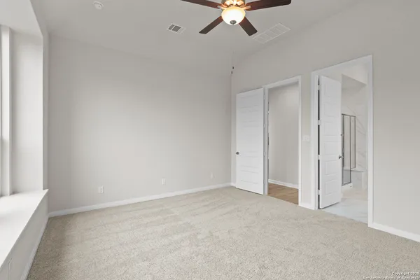 an empty room with chandelier fan