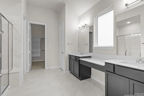 a bathroom with a sink double vanity granite and a mirror