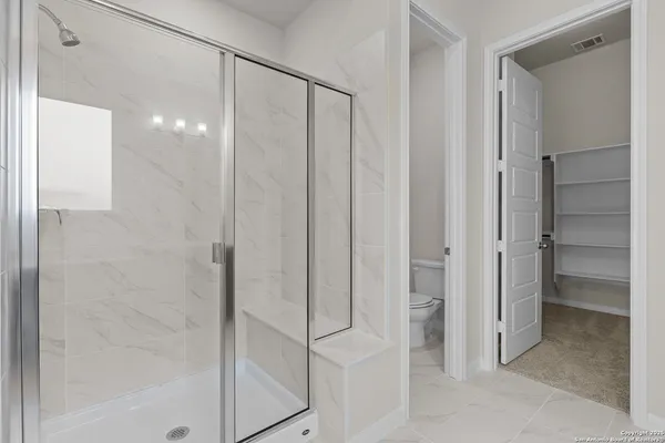 a bathroom with a shower and a glass door