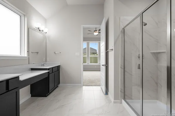 a bathroom with a granite countertop sink a mirror and a shower