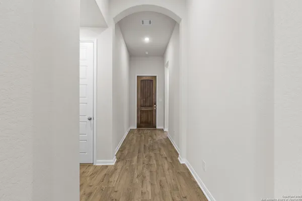 a view of a hallway with wooden floor