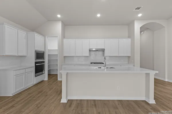 a kitchen with kitchen island a sink stainless steel appliances and cabinets