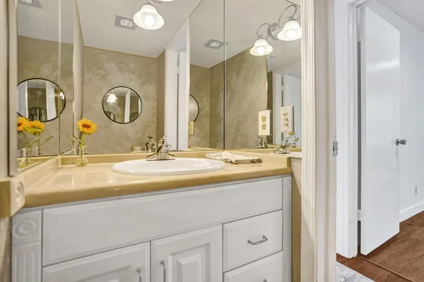 a bathroom with a granite countertop sink and a mirror