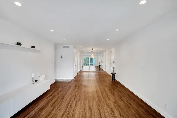 a view of empty room with wooden floor