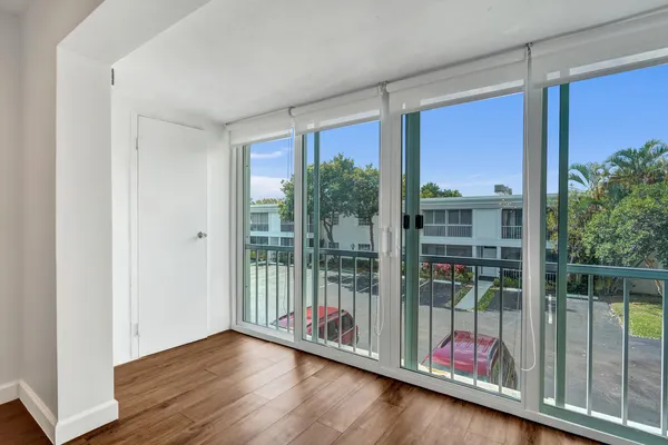 a view of a room with wooden floor and floor to ceiling window