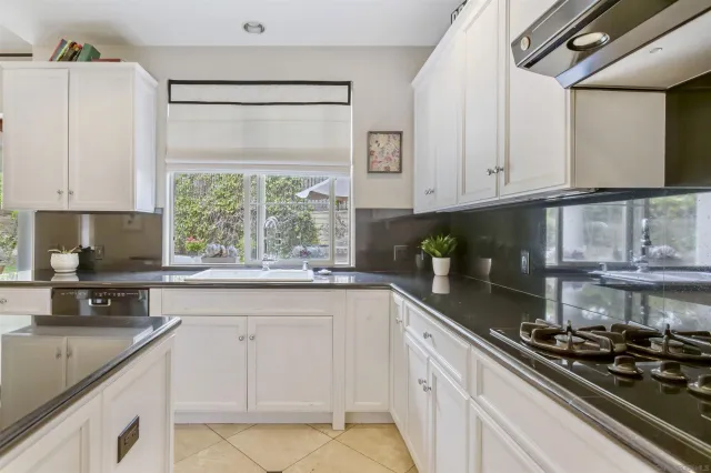 a kitchen with stainless steel appliances granite countertop a sink stove and cabinets