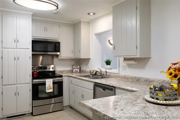a kitchen with stainless steel appliances granite countertop a sink stove and cabinets