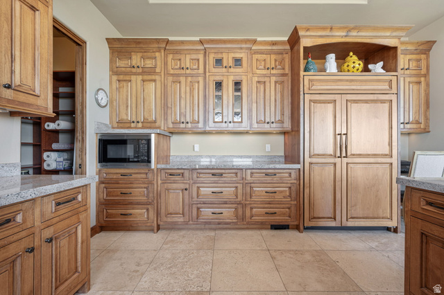 2331 West Entrada Trail, Unit 61 St. George, UT 84770 - Photo 16 of 69 Expansive kitchen featuring wood cabinetry with various storage options, light-toned stone countertops, and stone-look tile flooring