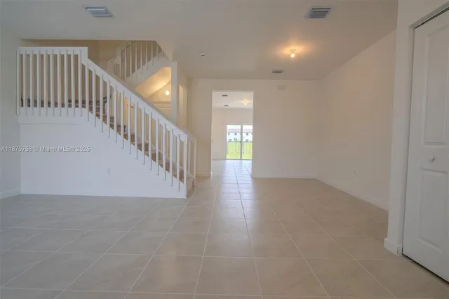 a big room with windows and chandelier fan
