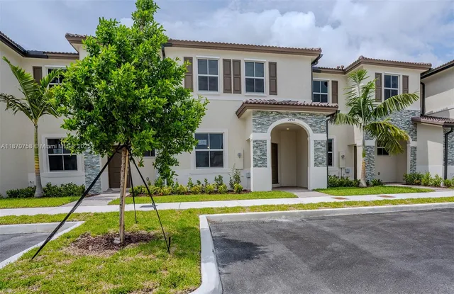 a view of a kitchen with a sink and dishwasher a refrigerator with white cabinets
