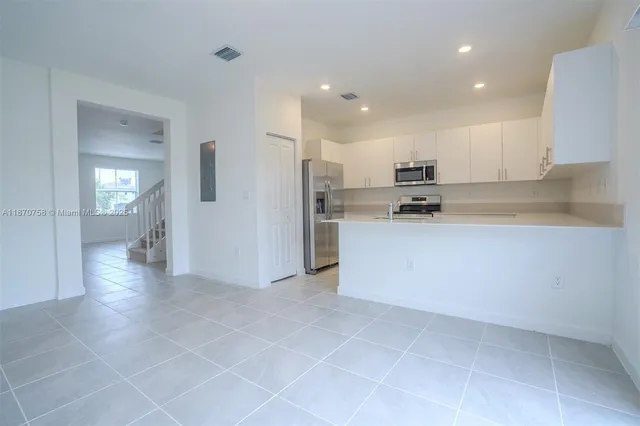 a kitchen with cabinets stainless steel appliances and a sink