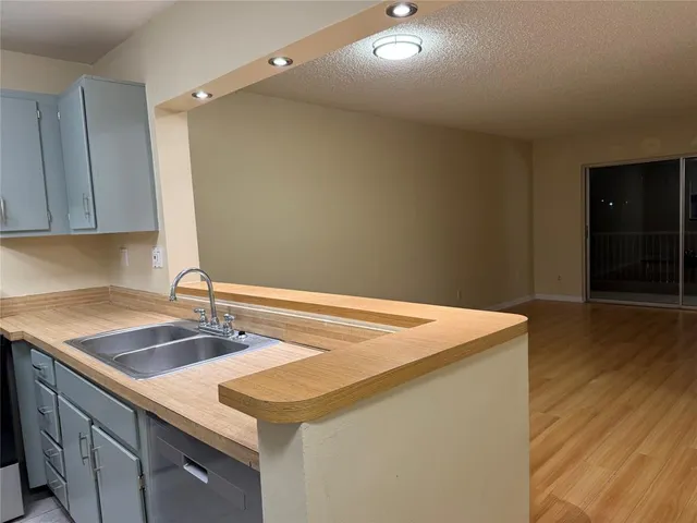 a room with kitchen island a sink and wooden floor